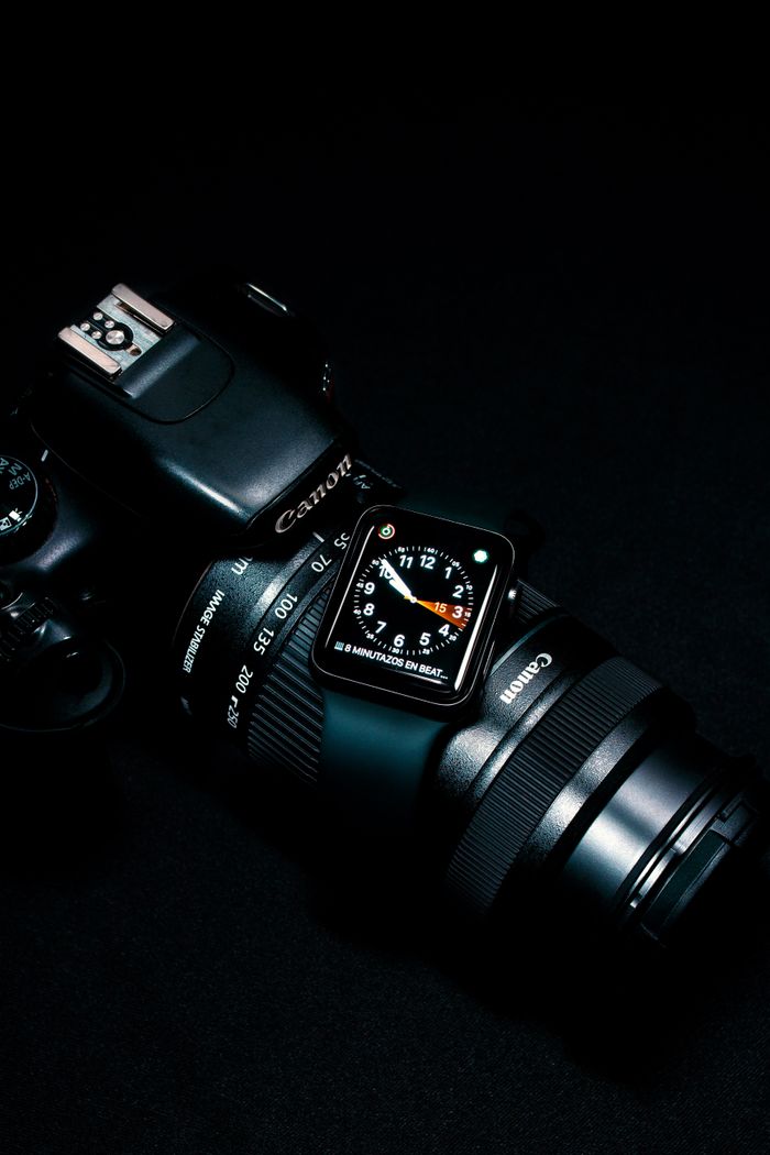 A sleek digital watch displayed on a DSLR Canon camera against a dark background. Perfect for tech enthusiasts.
