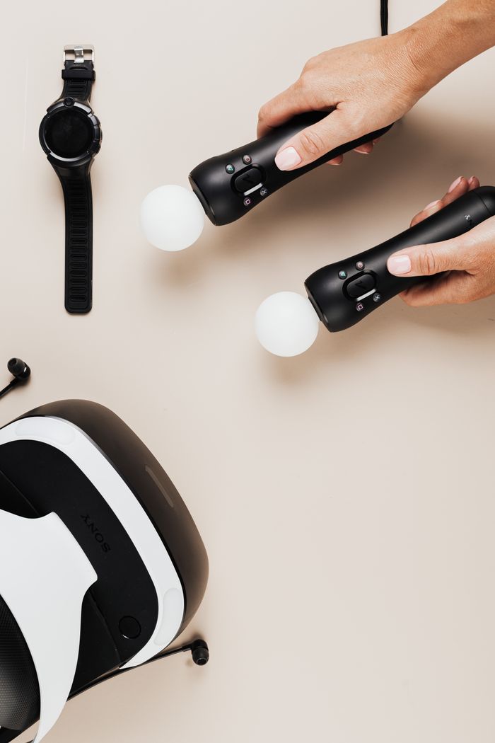 Hands holding VR controllers next to a headset. Perfect for tech enthusiasts.