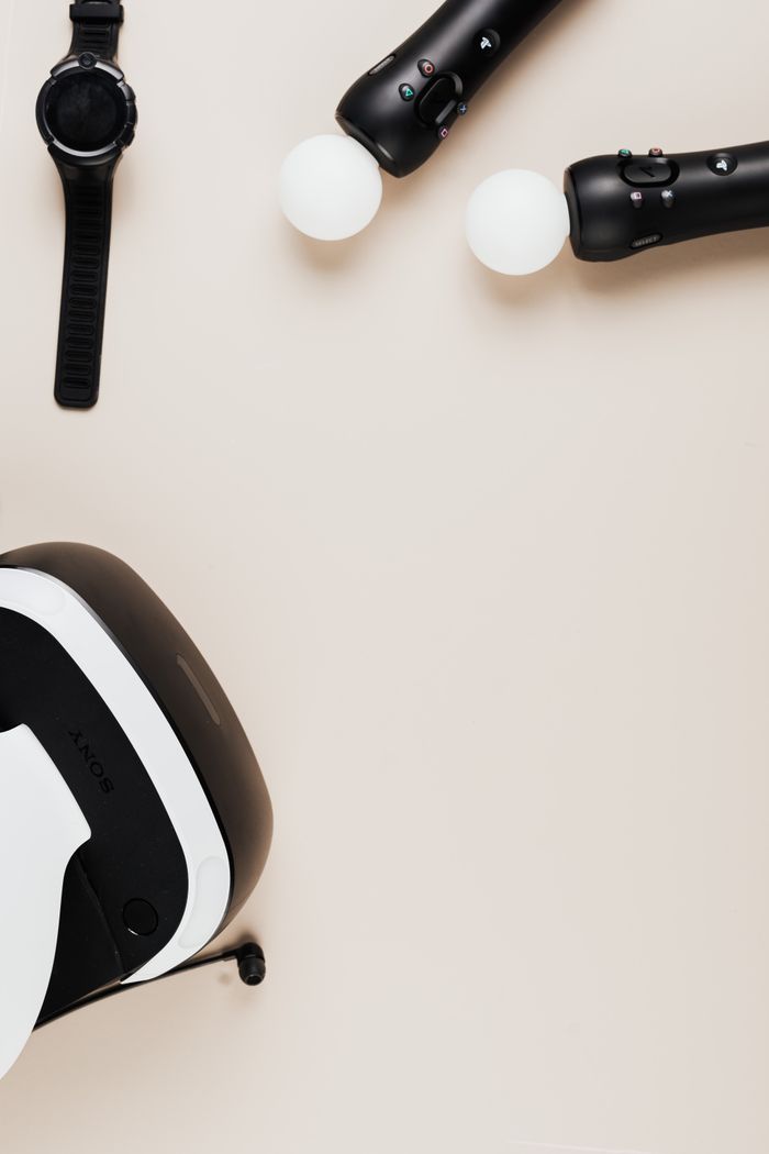 Top view of virtual reality headset and smartwatch on beige surface. Ideal for tech themes.